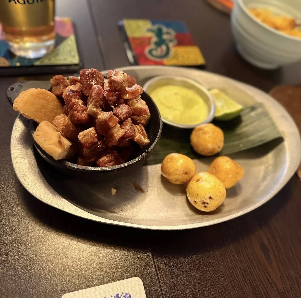 Chicharrón crocante con salsa, buñuelos y patacón como entrante en Tequendama
